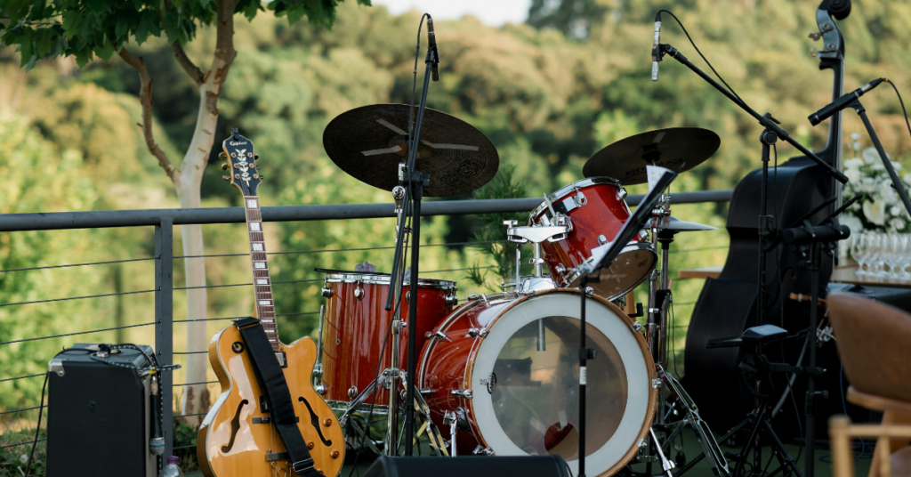 Drums and guitar on an outdoor stage.